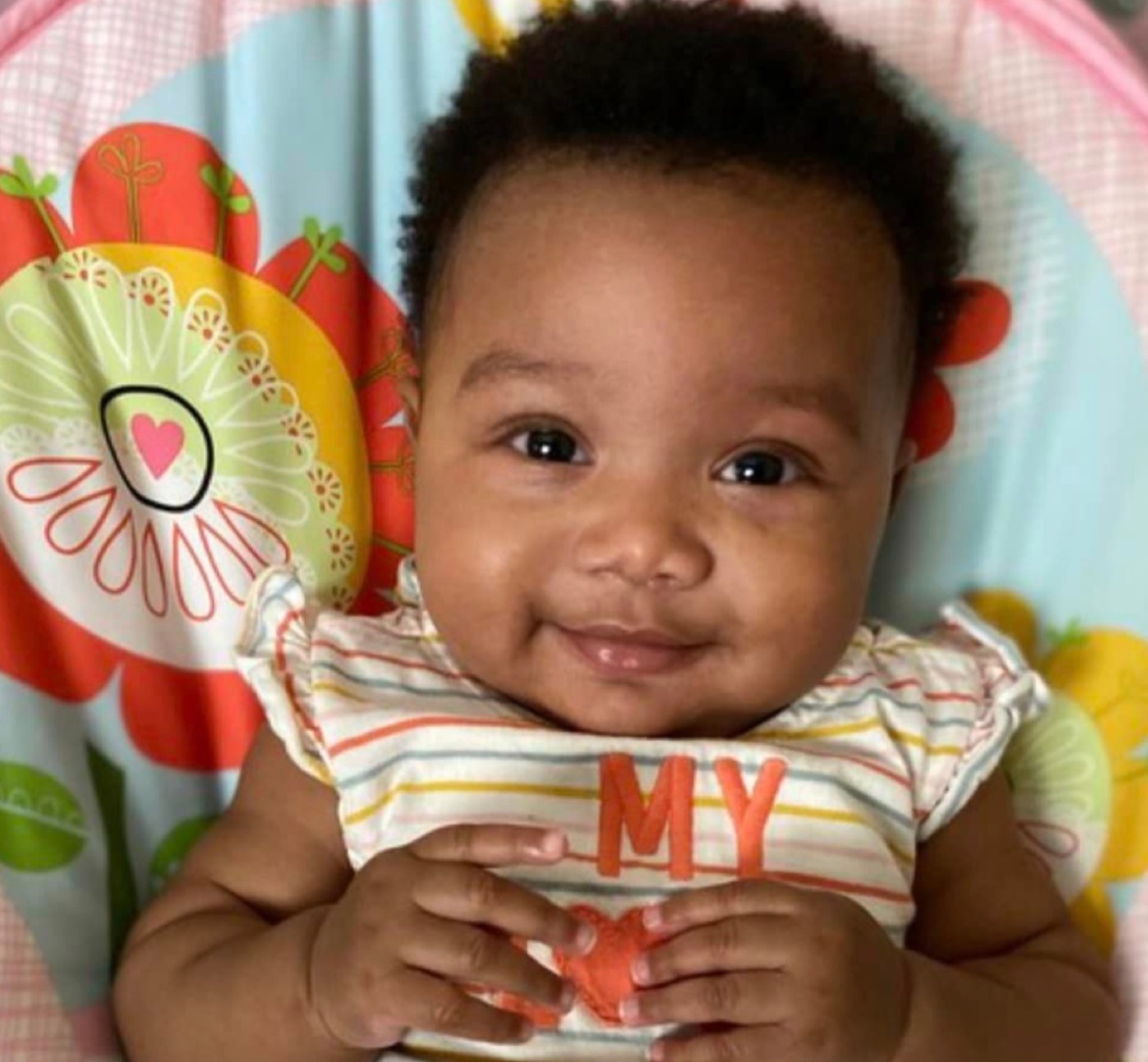 Smiling baby on a floral play mat